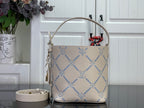 Louis Vuitton hobo bag in light beige with blue monogram print, top handle and tassel zipper pull