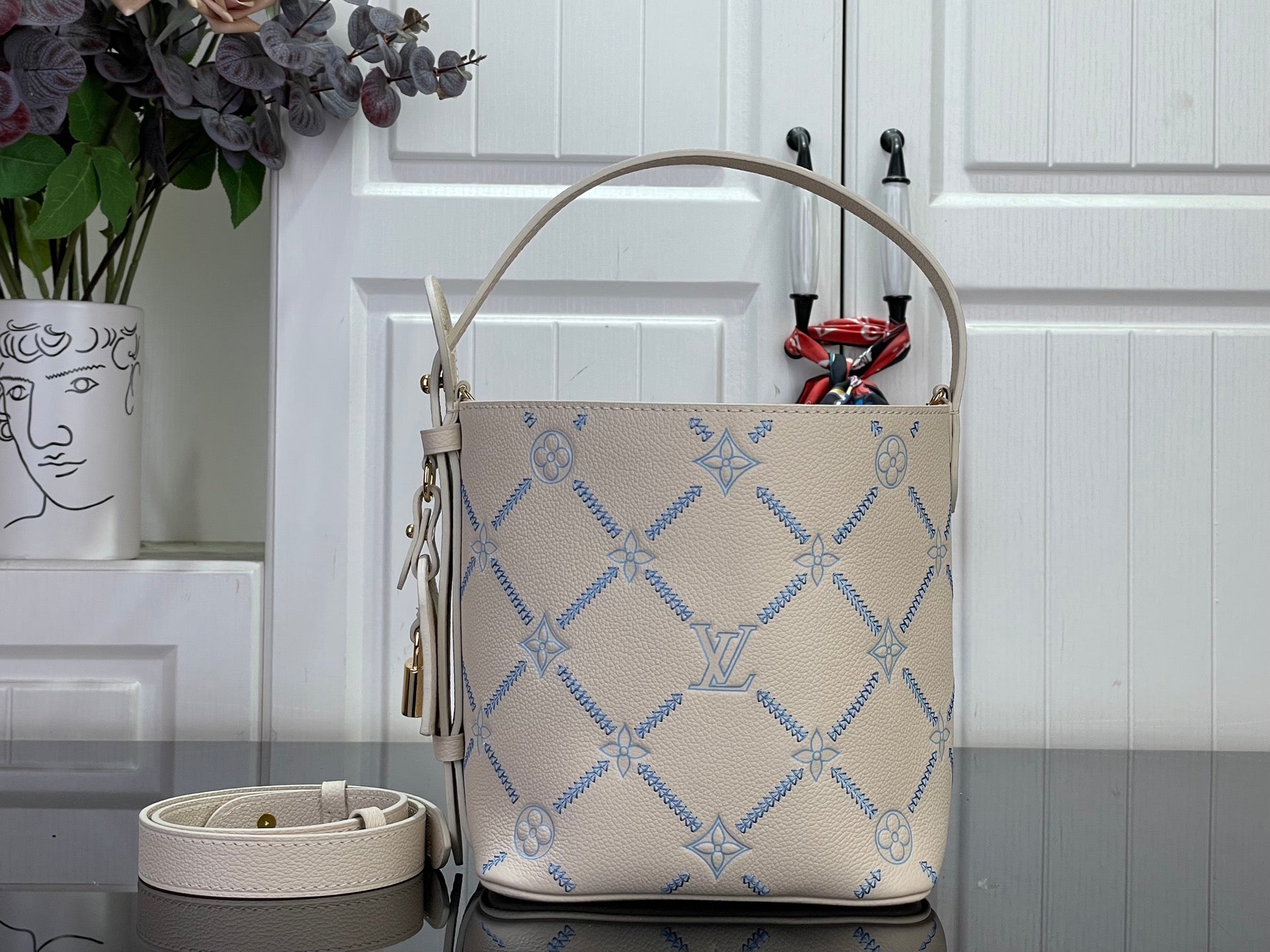 Louis Vuitton hobo bag in light beige with blue monogram print, top handle and tassel zipper pull