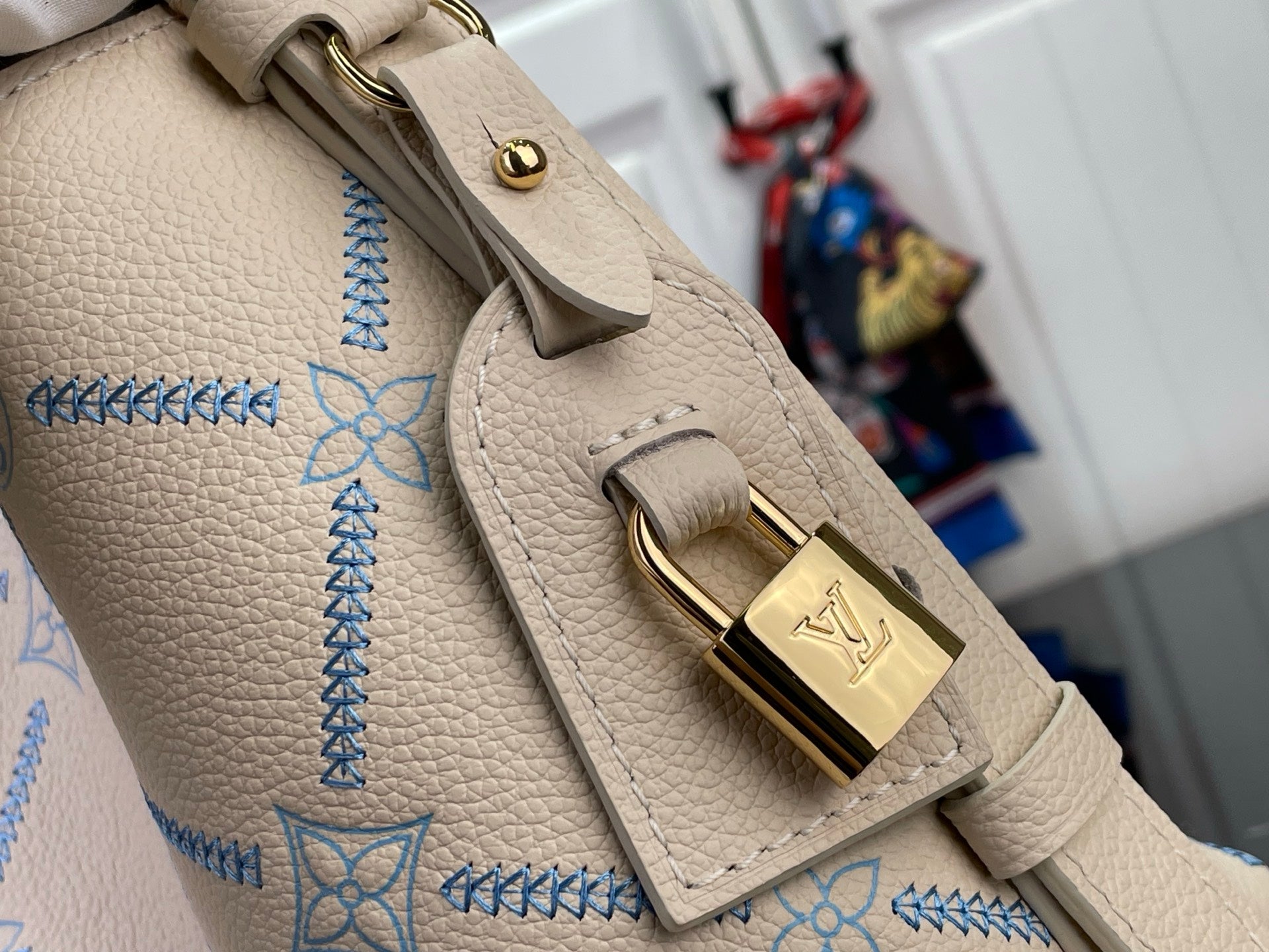 Louis Vuitton bag strap and handle hardware with gold clasp on light beige pebble leather
