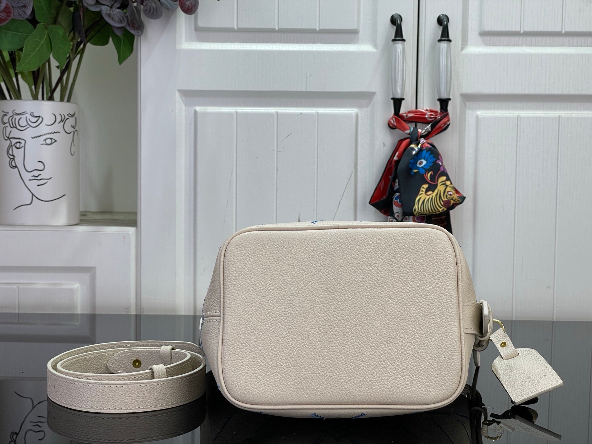 Louis Vuitton crossbody bag with textured light beige flap and attached charm keyring