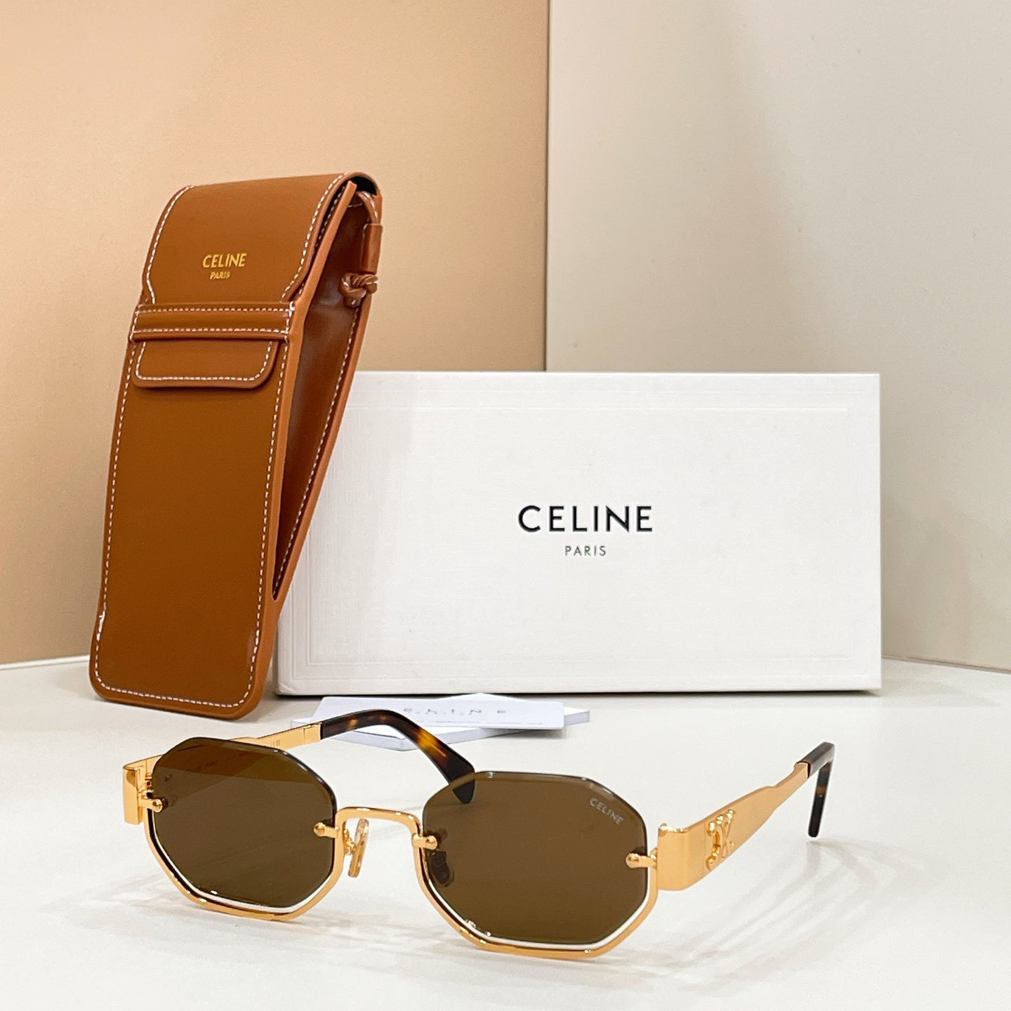 Celine sunglasses with dark lenses and gold-tone frame, shown with brown case