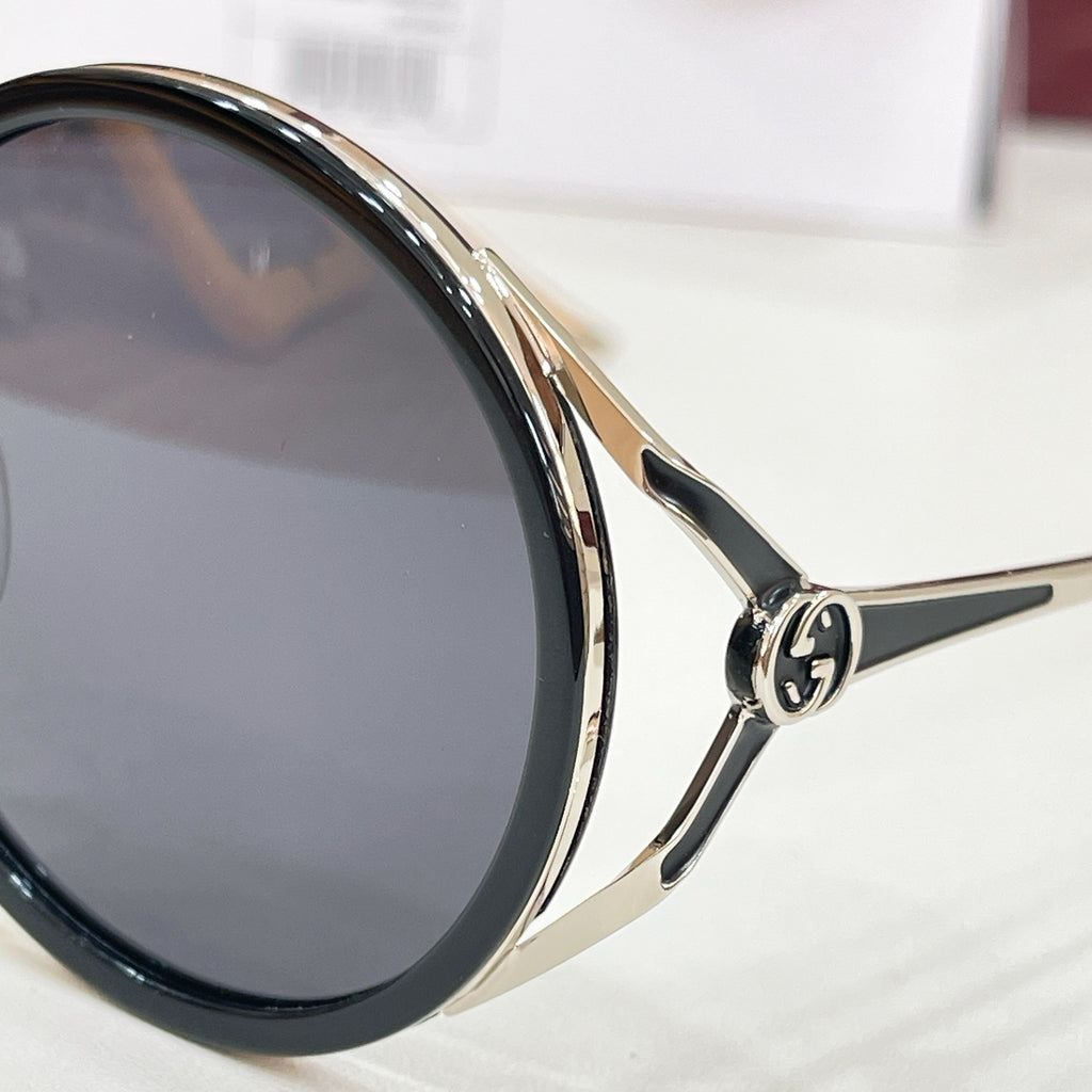 Gucci round sunglasses close-up, black lenses with gold-tone rim