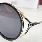 Gucci round sunglasses close-up, black lenses with gold-tone rim