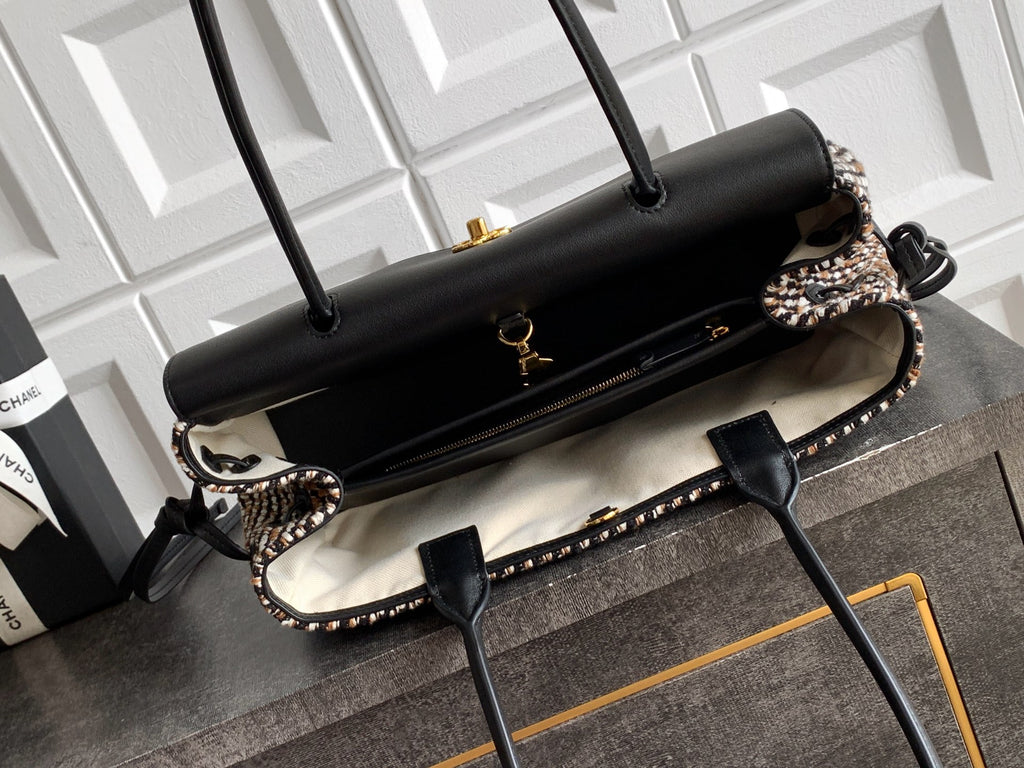 Chanel handbag with black leather flap and houndstooth side panels, gold-tone feet.