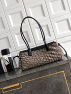 Chanel handbag with black leather handles and rectangular houndstooth woven body, gold logo.