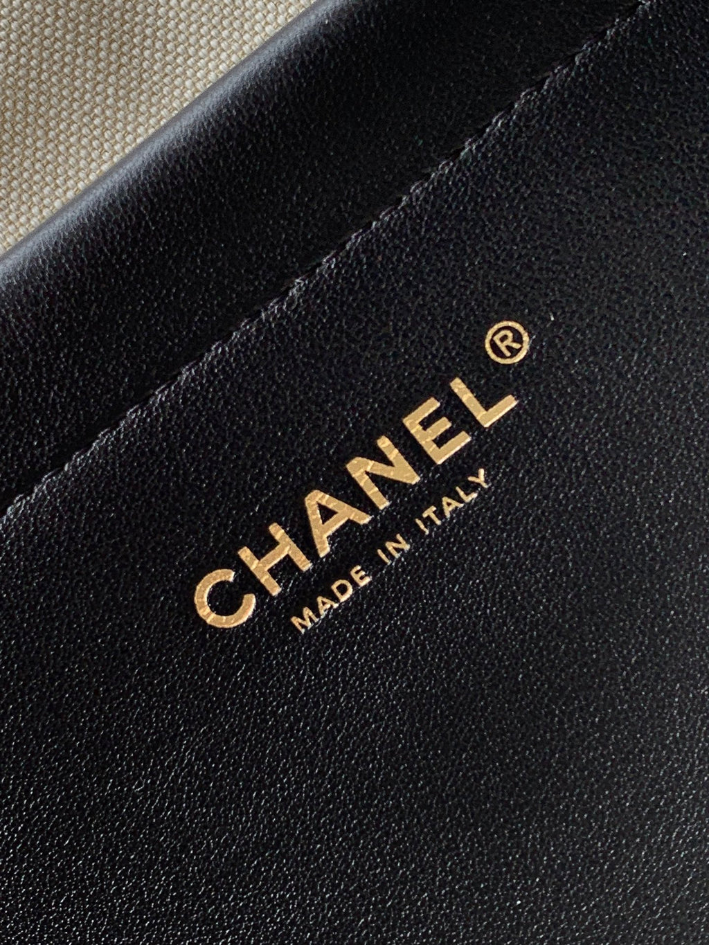 Chanel logo and “MADE IN ITALY” on black leather handbag panel