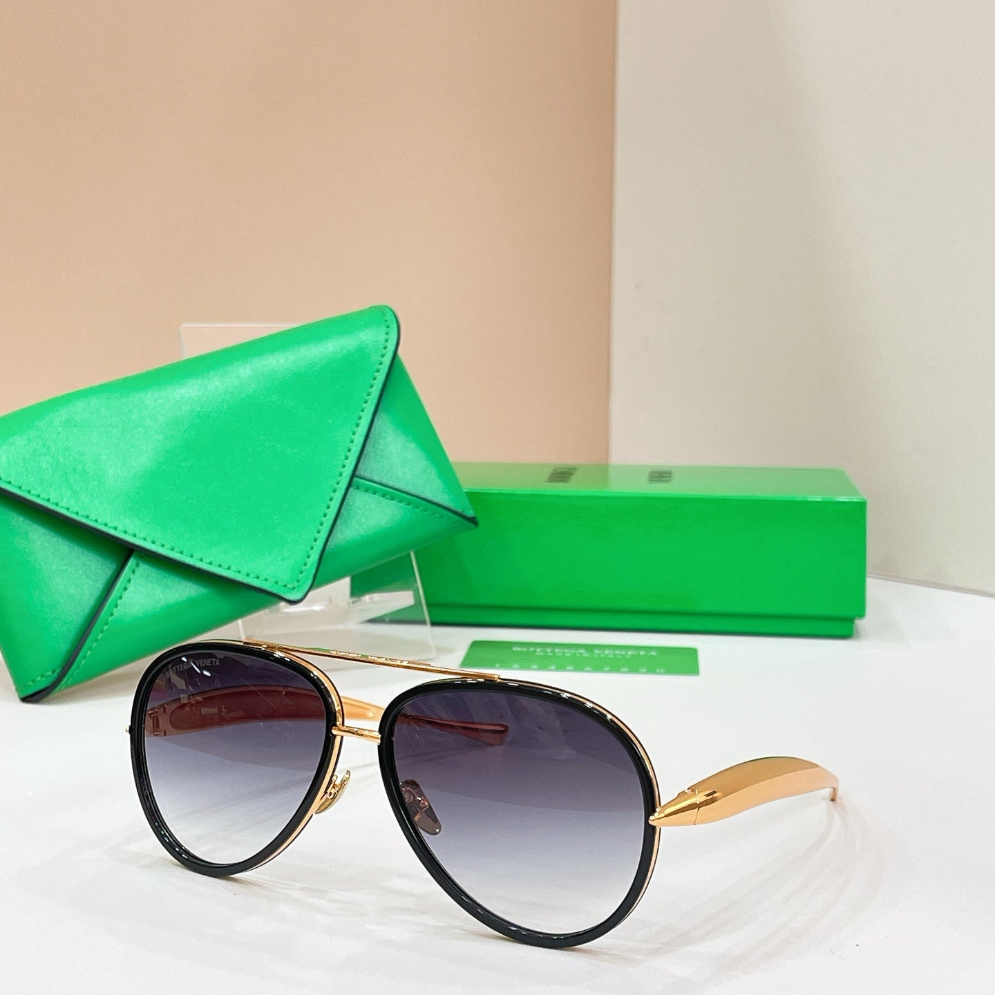 Round sunglasses with black frames and gold-tone accents, dark tinted lenses