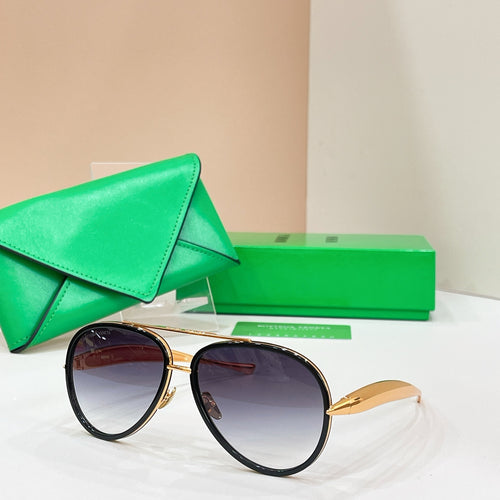 Round sunglasses with black frames and gold-tone accents, dark tinted lenses