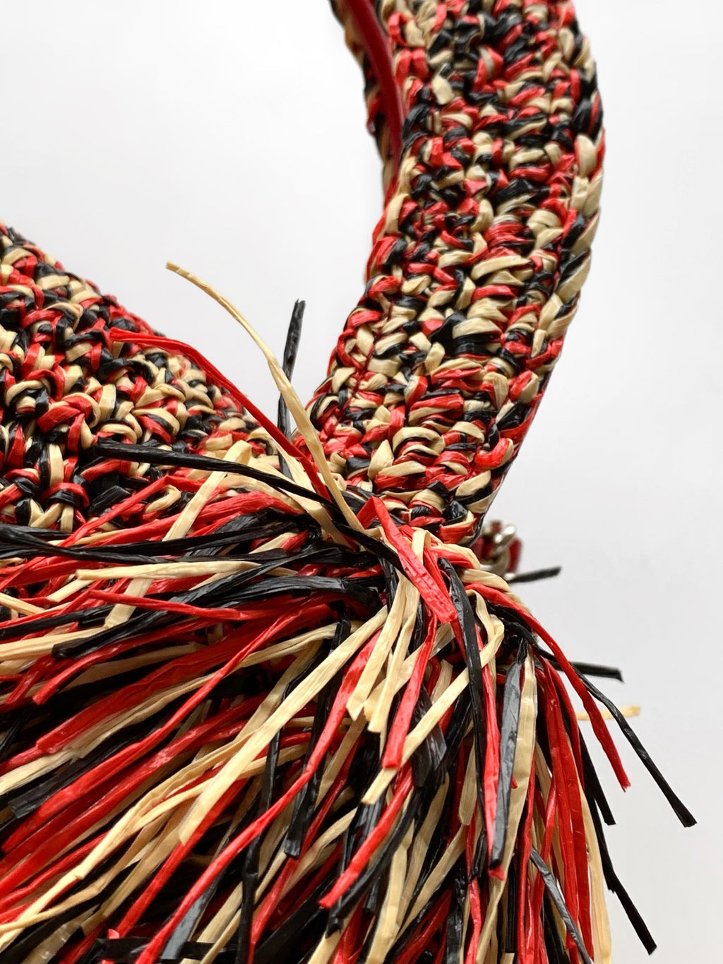Chanel fringe handbag corner with red, black, and cream tassel threads