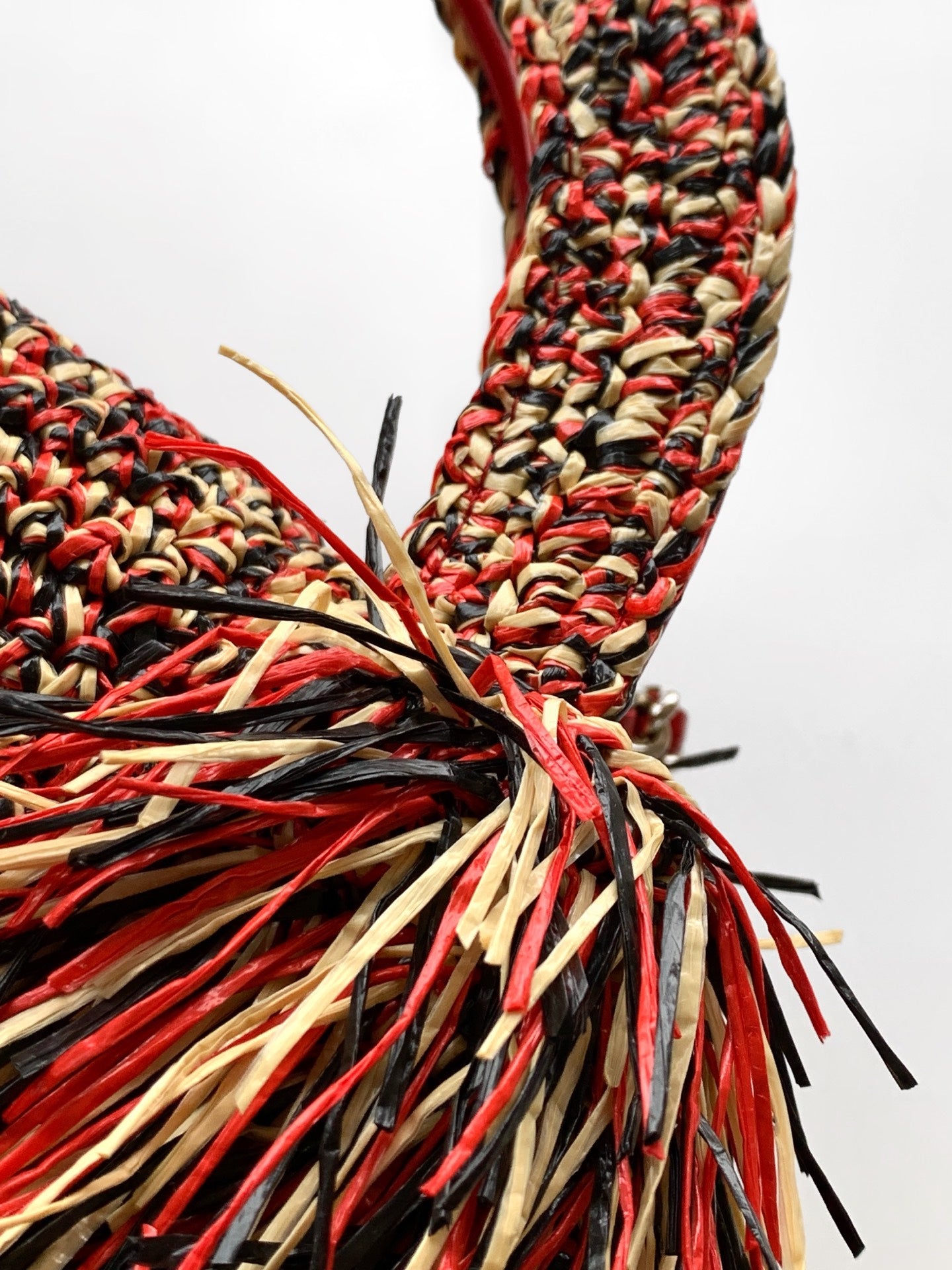 Chanel fringe handbag corner with red, black, and cream tassel threads