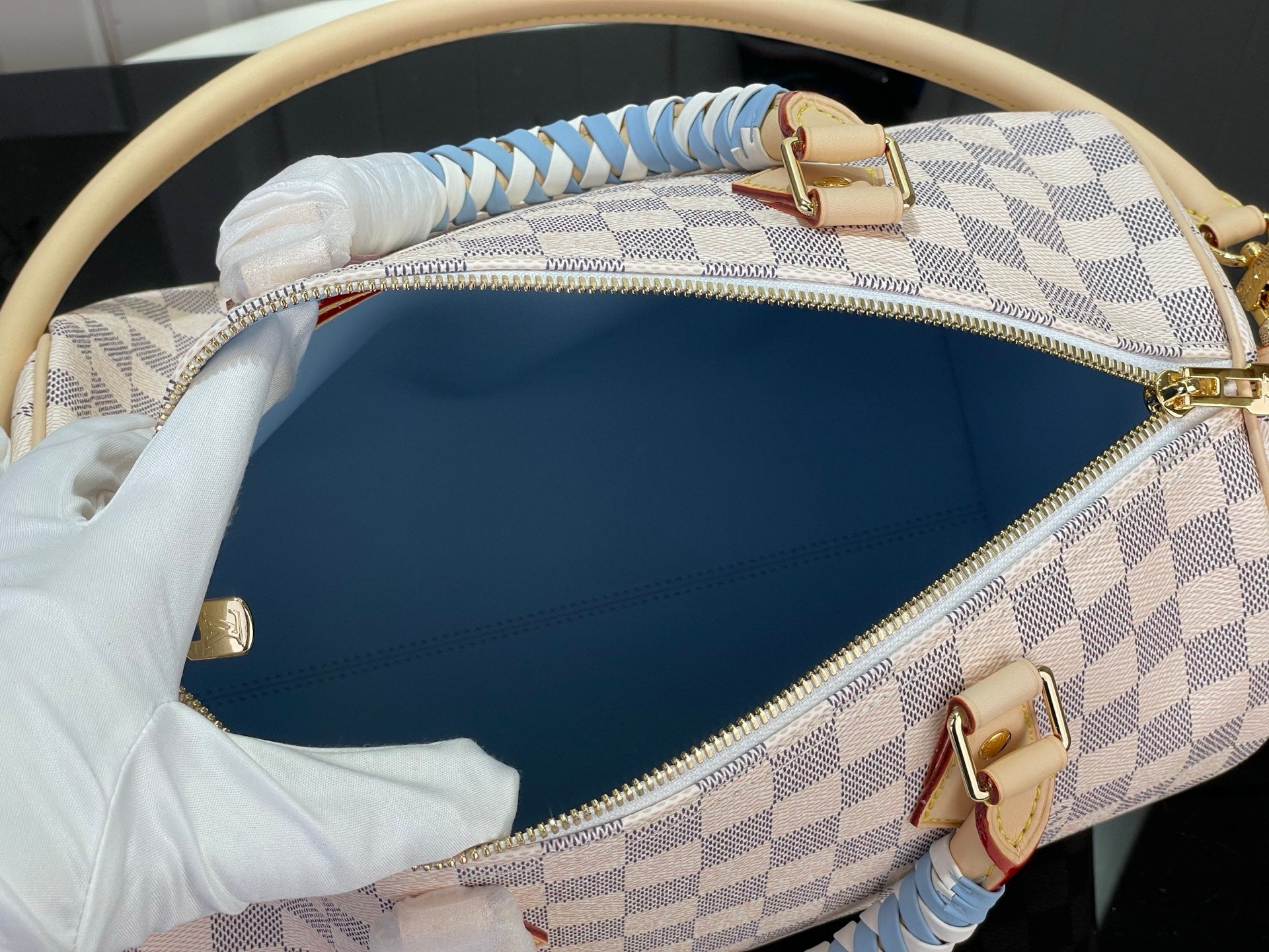 Damier check canvas bag with blue interior, top zipper and gold-tone hardware