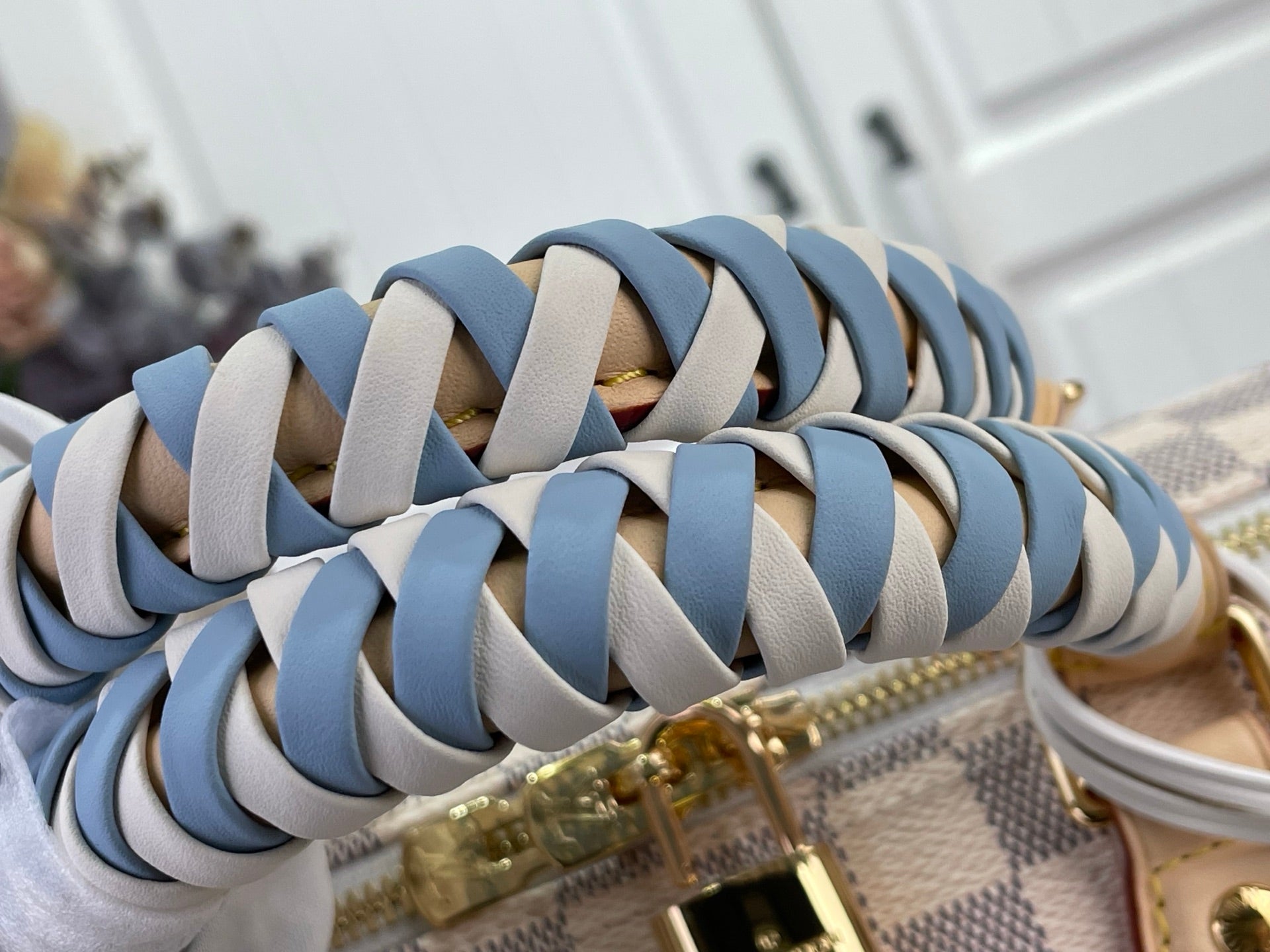Louis Vuitton Damier handbag braided handle close-up with blue-and-tan straps