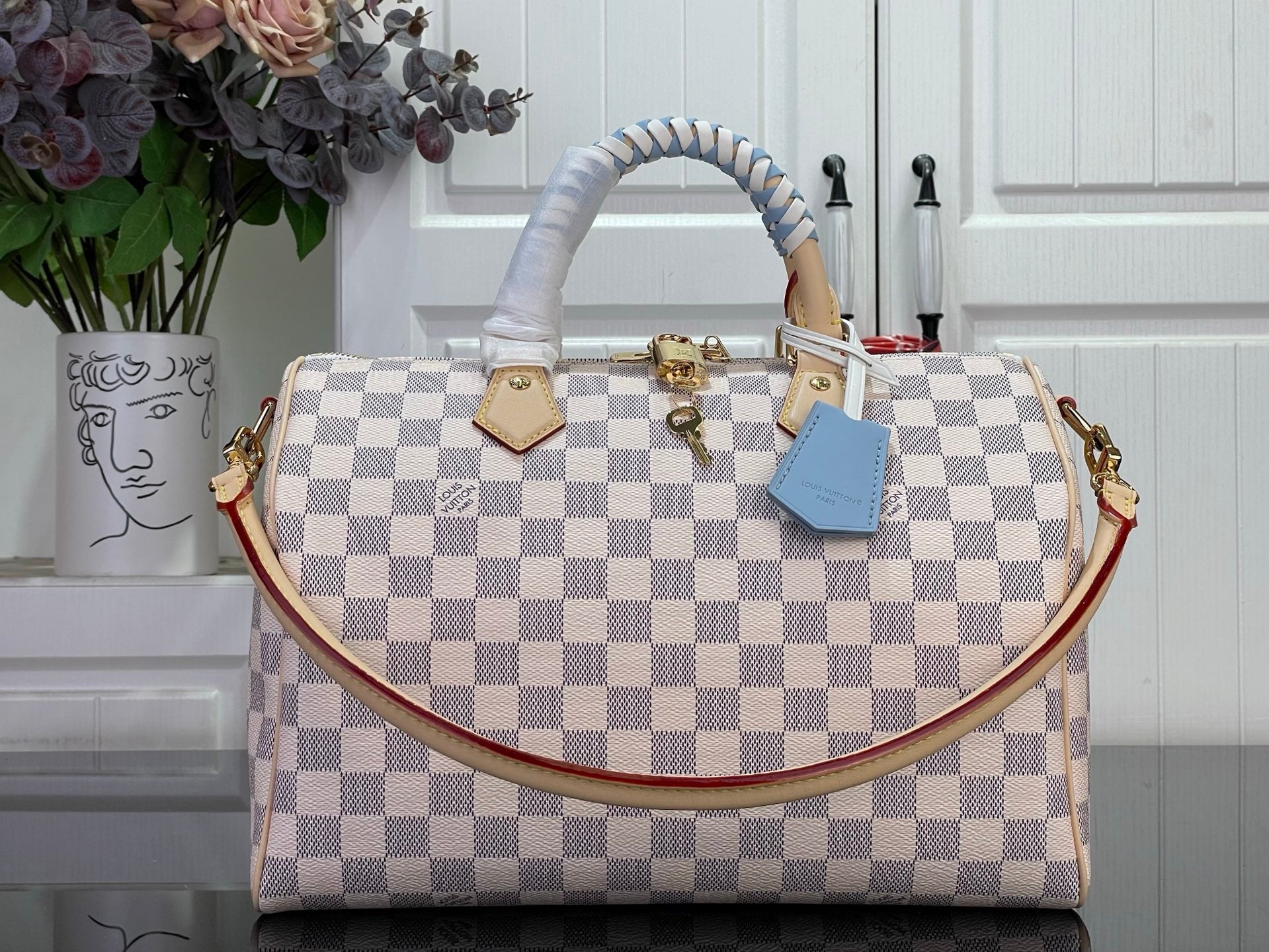 Louis Vuitton Damier checkered handbag with top handles and blue accessory tag