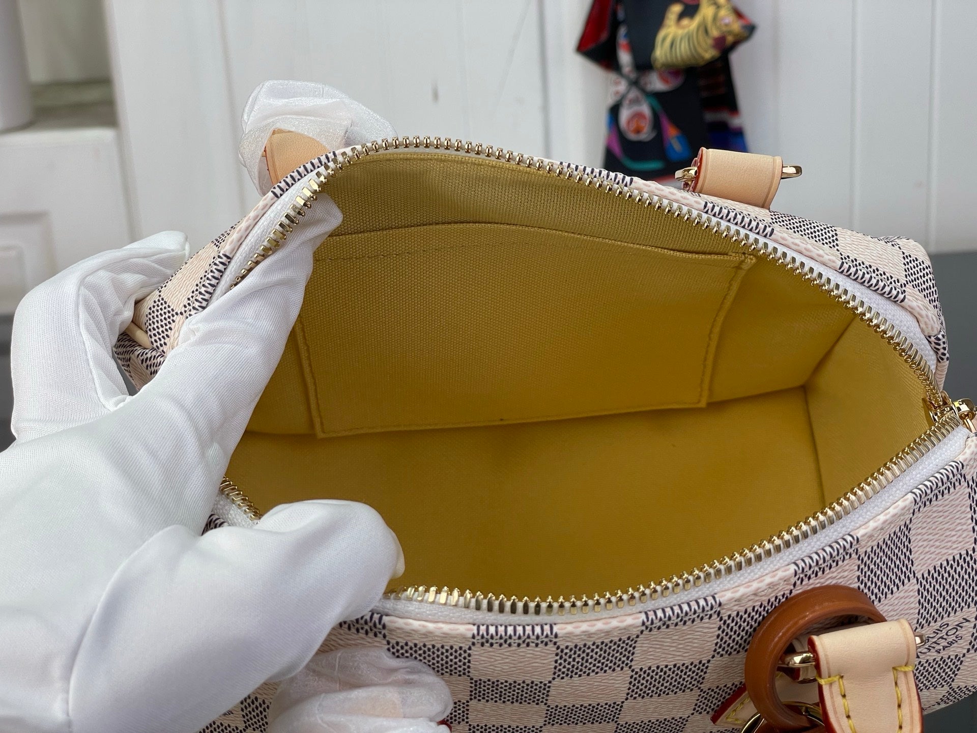 Louis Vuitton Damier check bag interior with gold-tone zipper and tan leather trim