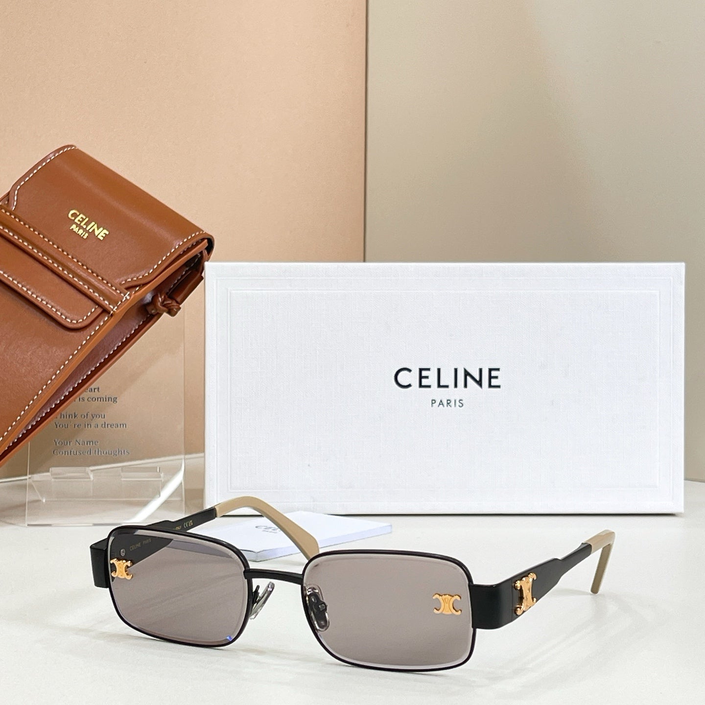 Square sunglasses with dark frame, gold accents, and dark tinted lenses