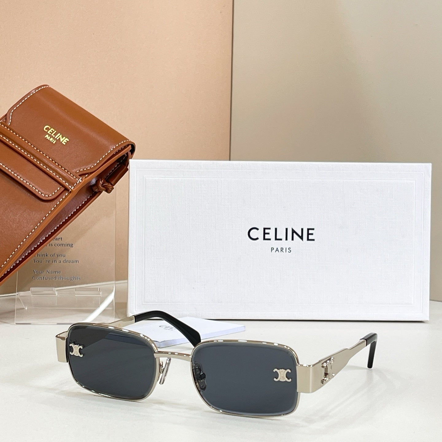 Square sunglasses with black frame, gold accents, and dark tinted lenses