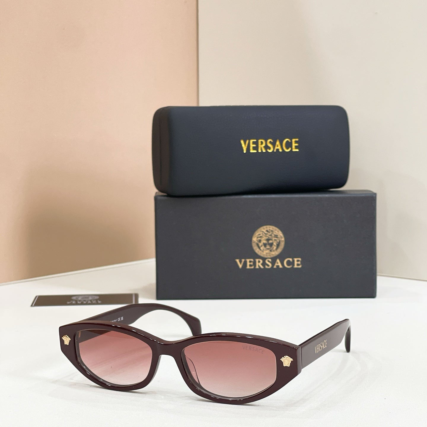 Versace sunglasses with dark brown frames and pink gradient lenses