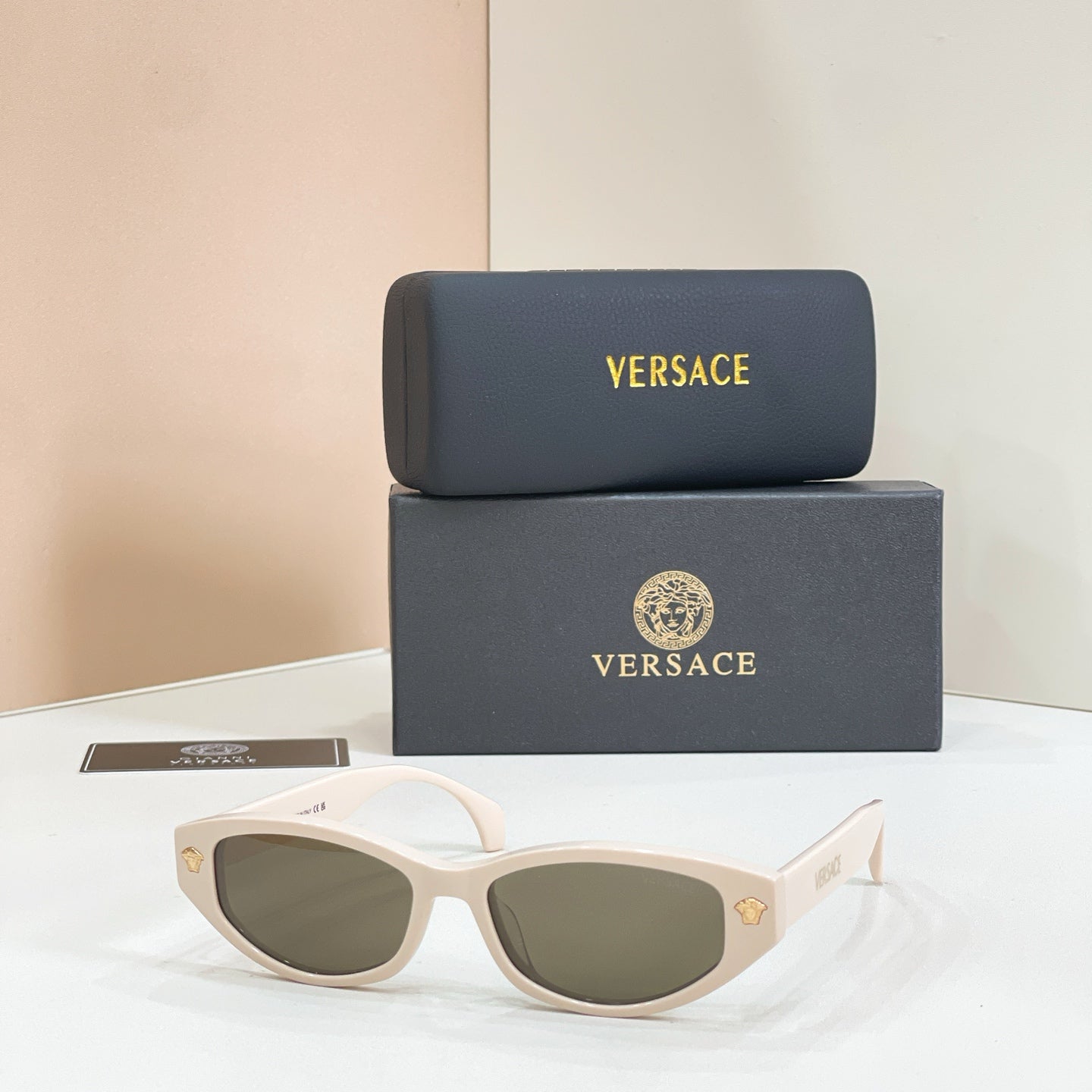 Versace sunglasses with white frames and green-tinted lenses