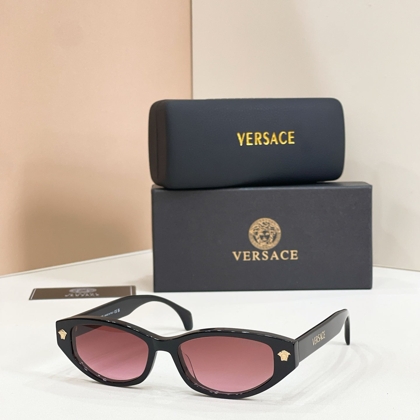 Versace sunglasses with black frames and pink gradient lenses