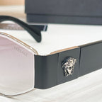 Versace sunglasses side detail, black temple with gold lion emblem and dark lens