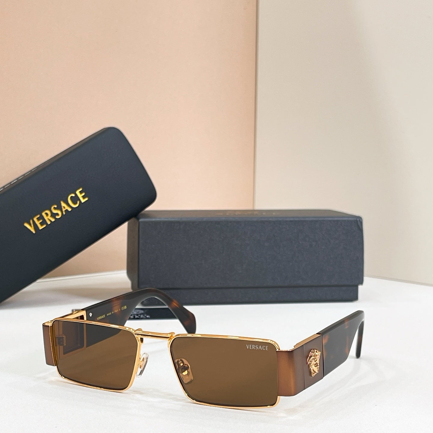 Rectangular Versace sunglasses with gold frame and brown gradient lenses.