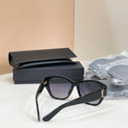 Black cat-eye sunglasses with purple lenses and gold YSL logo on side arm.