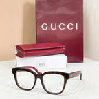 Gucci acetate glasses with dark tortoise frames, green temple detail, clear lenses