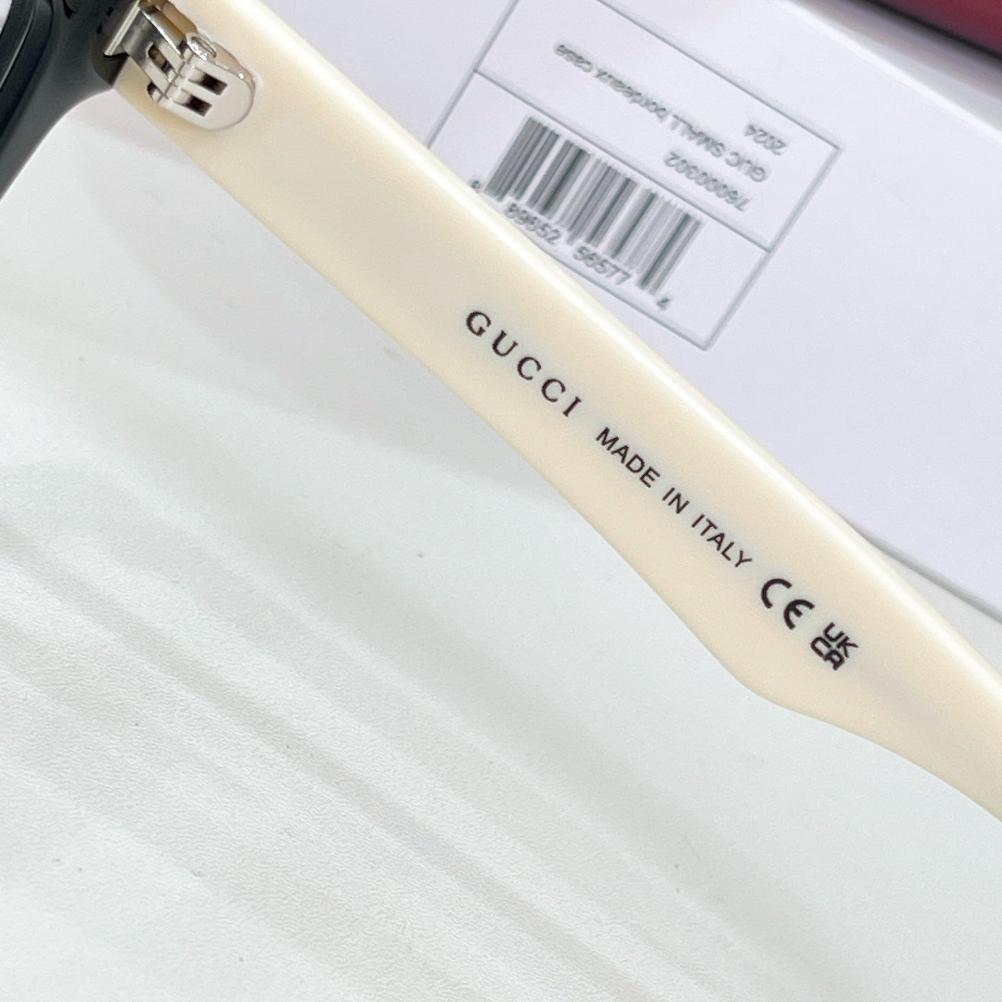 Gucci acetate glasses temple close-up with 'Made in Italy' text, clear lens