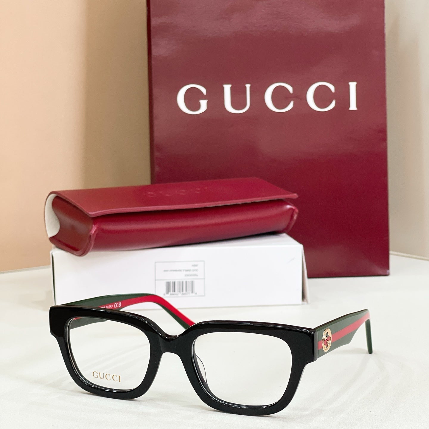 Gucci eyeglasses with black square frames and clear lenses, red-and-green temples