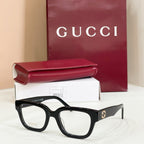 Gucci eyeglasses with black frames and clear lenses, red-and-green striped temples