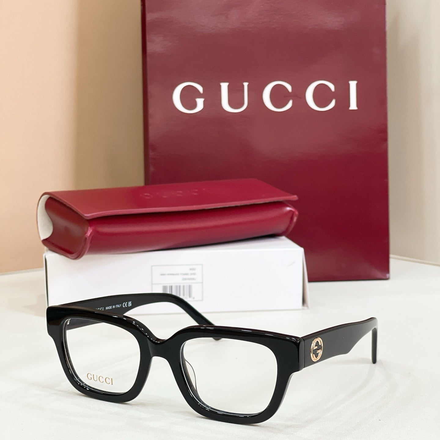 Gucci eyeglasses with black frames and clear lenses, red-and-green striped temples