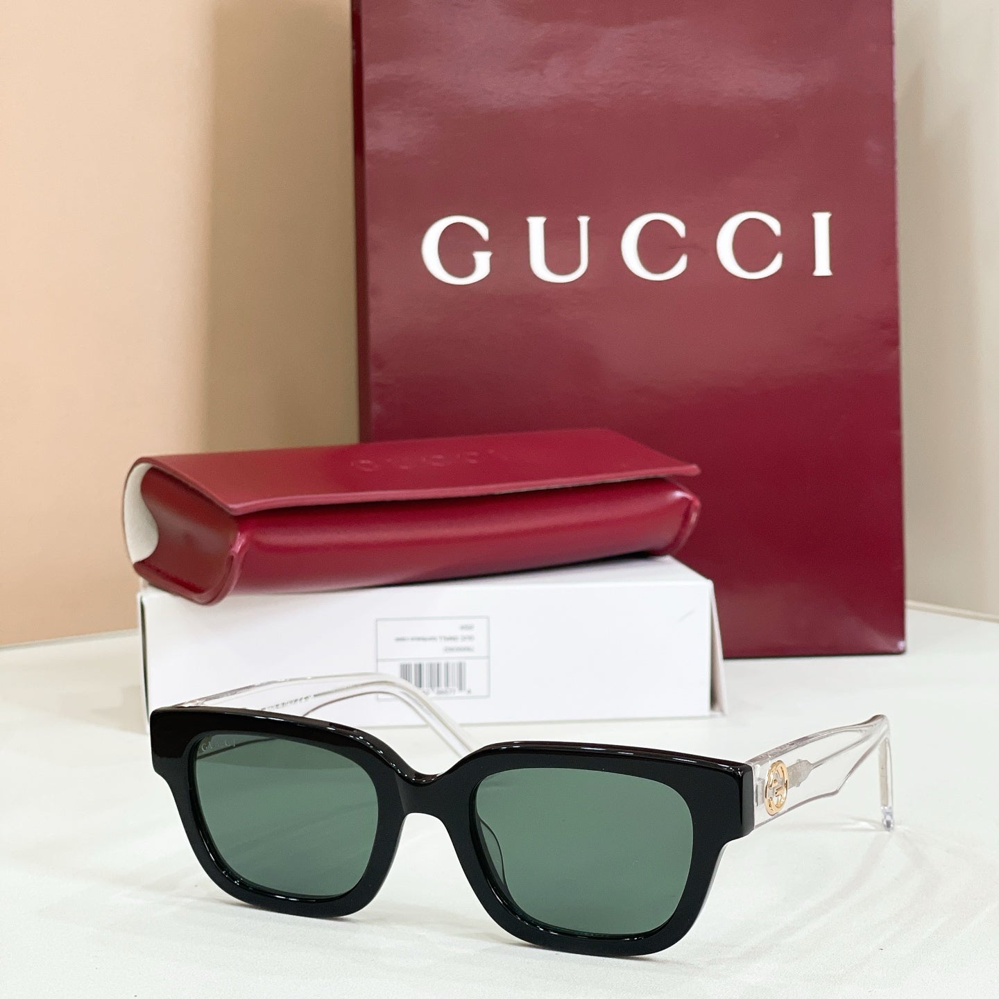 Gucci sunglasses with dark lenses and black frames, red-and-green temple accents