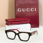 Gucci eyeglasses with dark frames and clear lenses, red-and-green striped temple arms