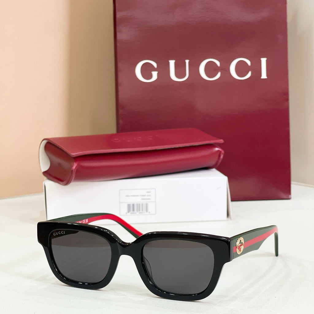 Gucci sunglasses with black frames and dark lenses, red-and-green striped temples