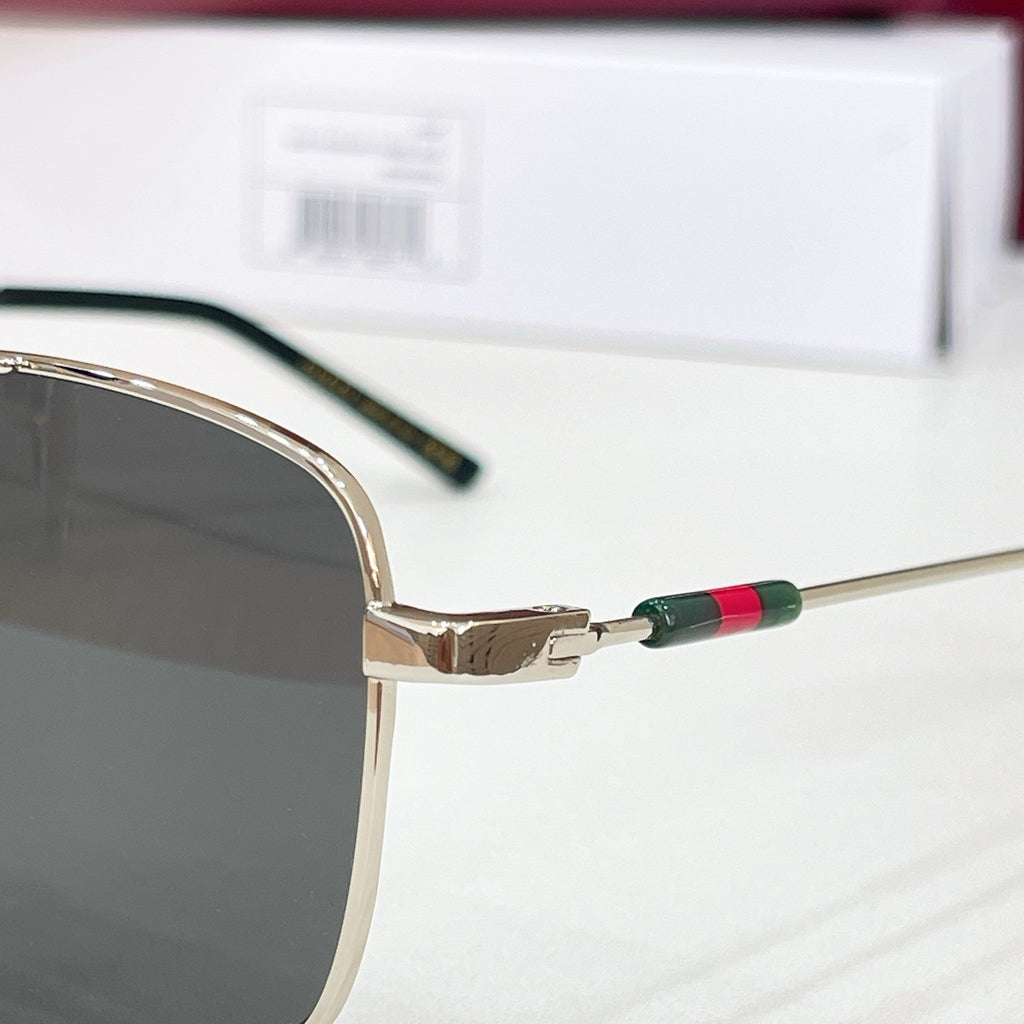 Gucci sunglasses close-up of gold bridge with green-red temple accents