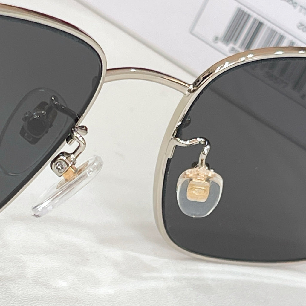 Gucci sunglasses close-up of gold bridge with dark lenses and rhinestone detail