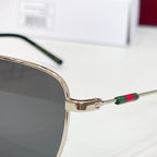 Gucci sunglasses close-up of gold temple with multicolor stripe and dark lens