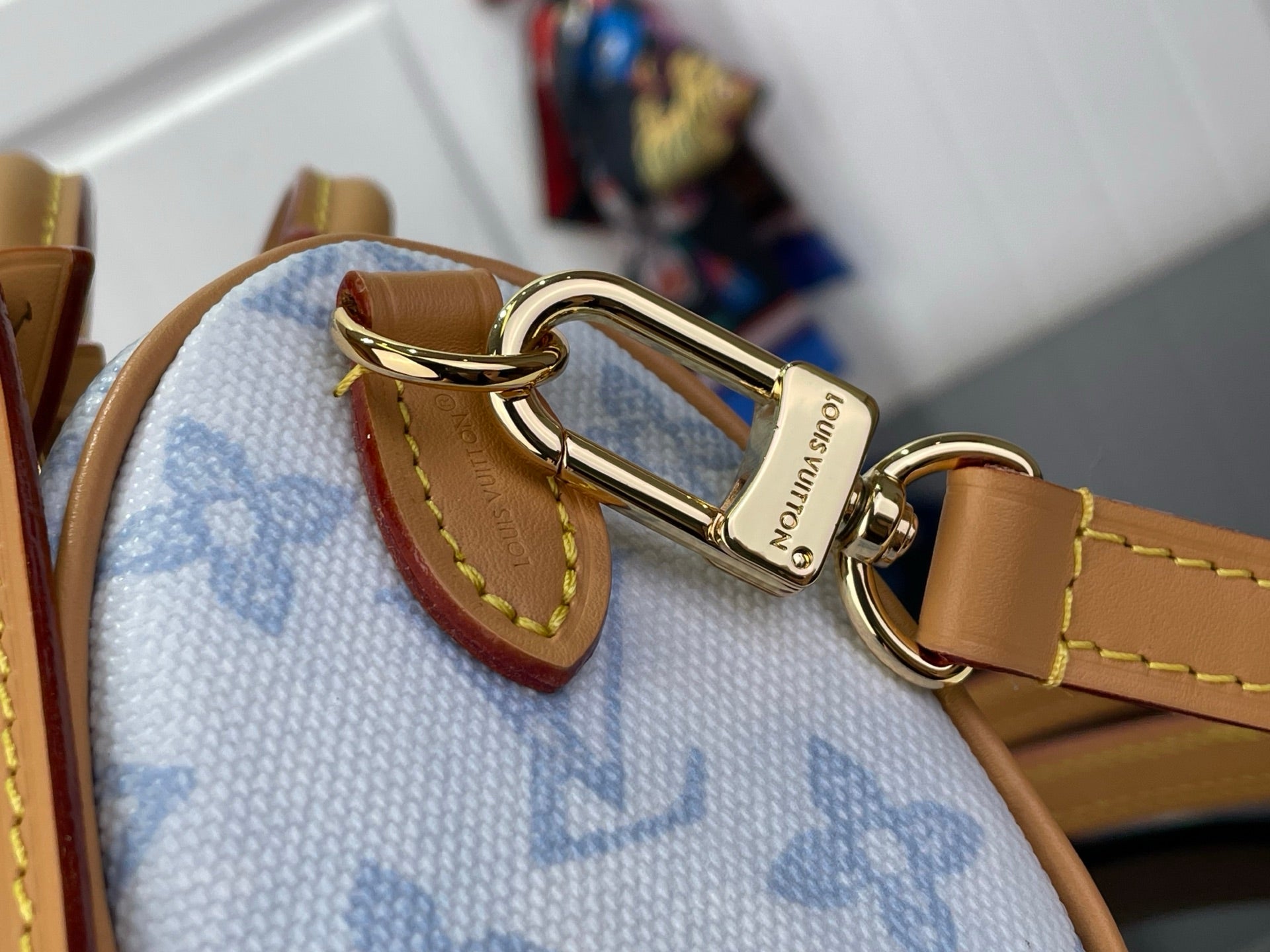 Louis Vuitton bag strap clasp with gold hardware on light blue monogram canvas