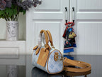 Louis Vuitton handbag in light blue monogram with tan strap and rolled top handles