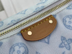 Tan leather zipper pull patch on light blue monogram canvas bag