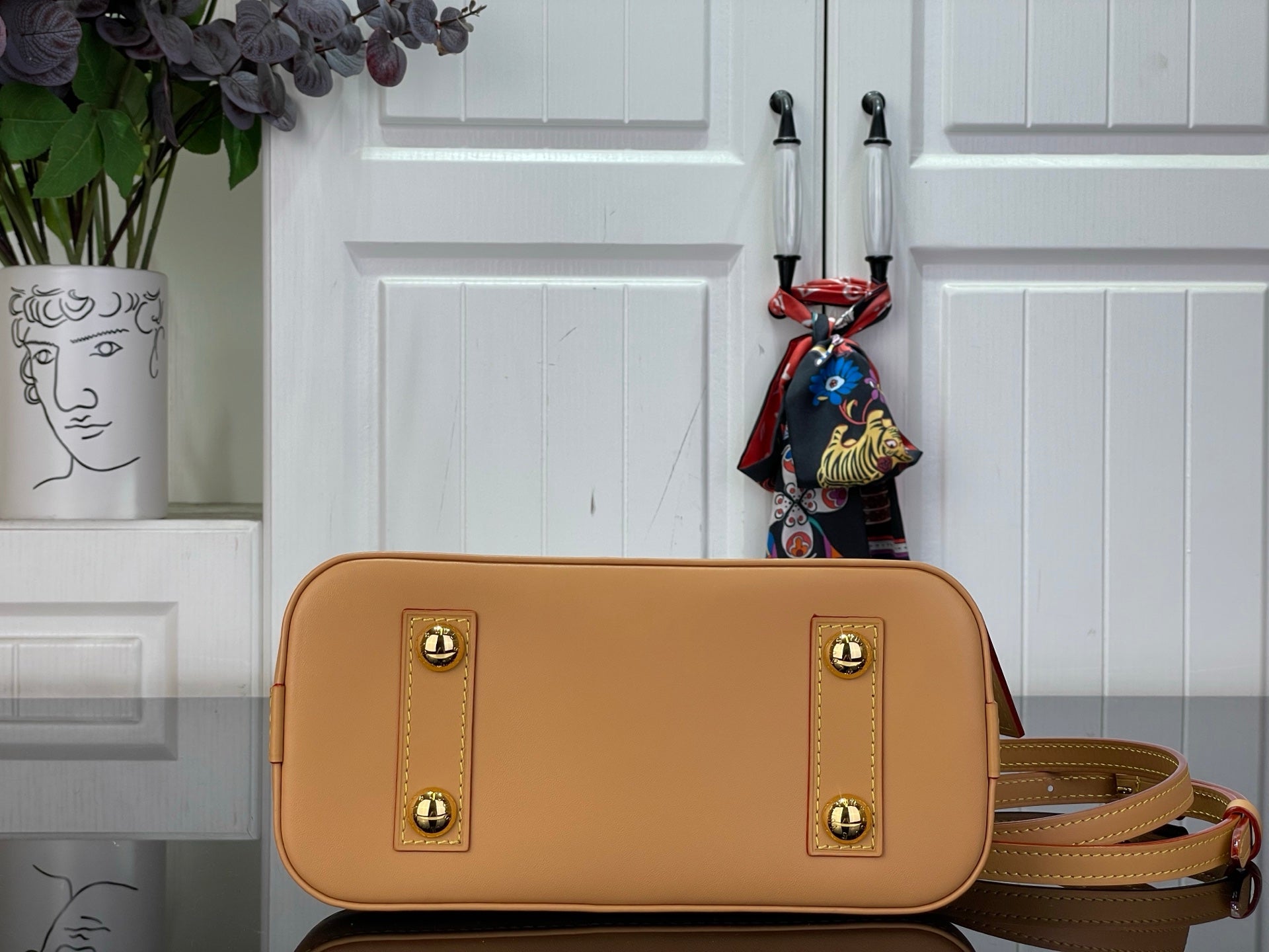 Louis Vuitton monogram shoulder bag with tan flap, gold hardware, and crossbody strap.