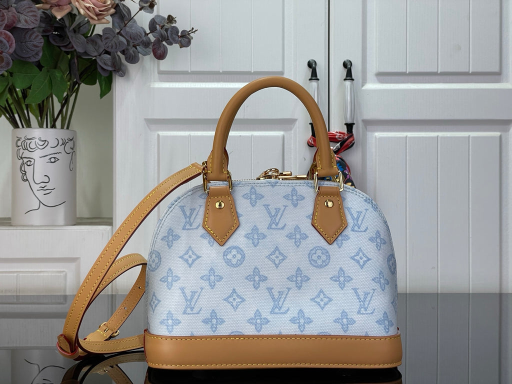 Louis Vuitton monogram handbag in blue with tan leather straps and central top handles.