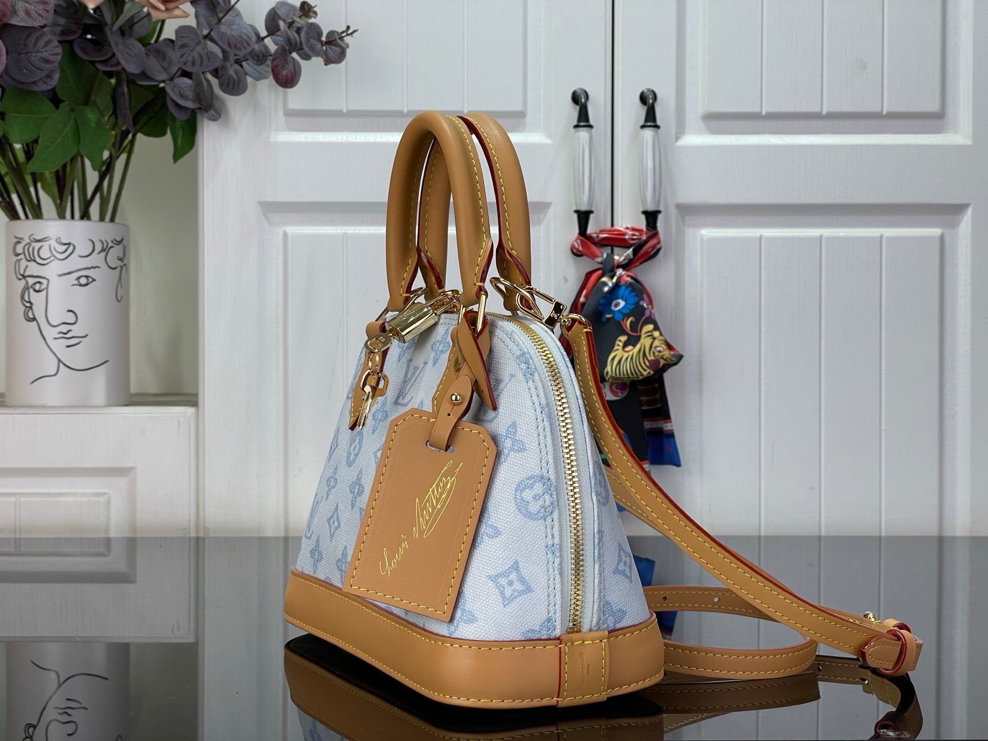 Louis Vuitton monogram handbag, blue canvas with tan trim and crossbody shoulder strap.