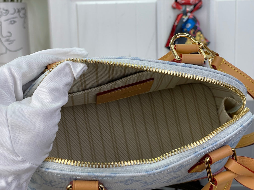 Louis Vuitton monogram bag interior with lined pocket and gold zipper edge visible.