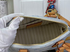 Louis Vuitton monogram bag interior with lined pocket and gold zipper edge visible.