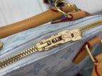 Blue monogram bag zipper with gold Louis Vuitton hardware and pull tab detail.