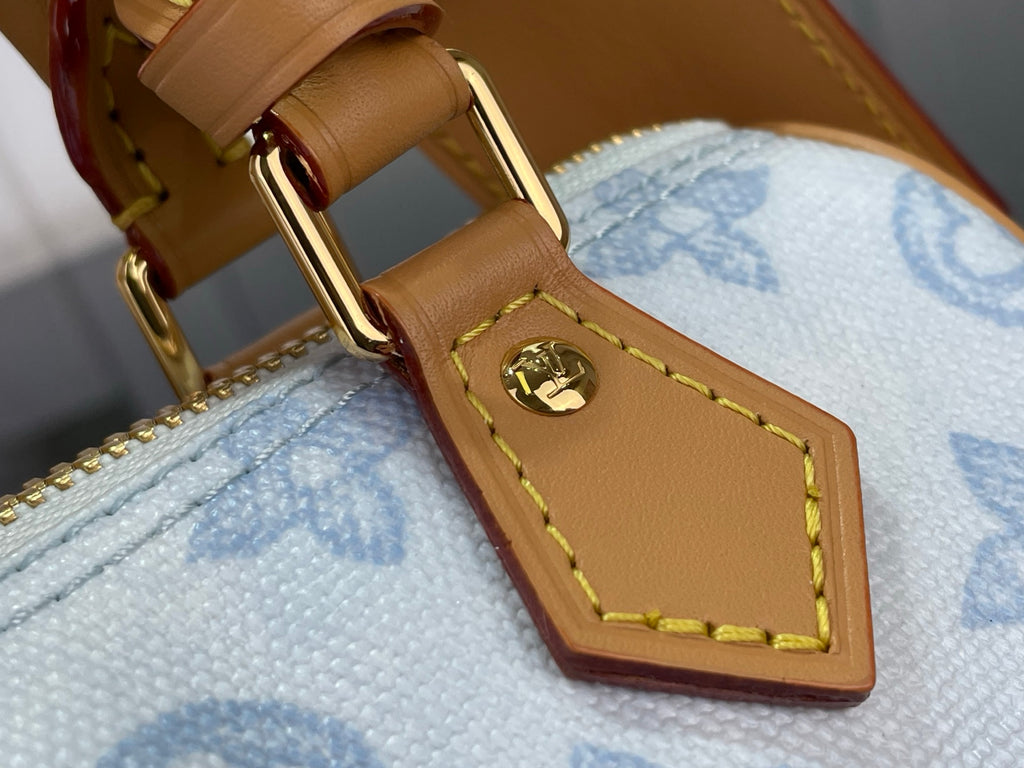 Leather bag handle strap with gold buckle hardware and yellow stitching, light blue lining