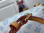 Blue monogram handbag close-up: tan and red strap with gold ring hardware