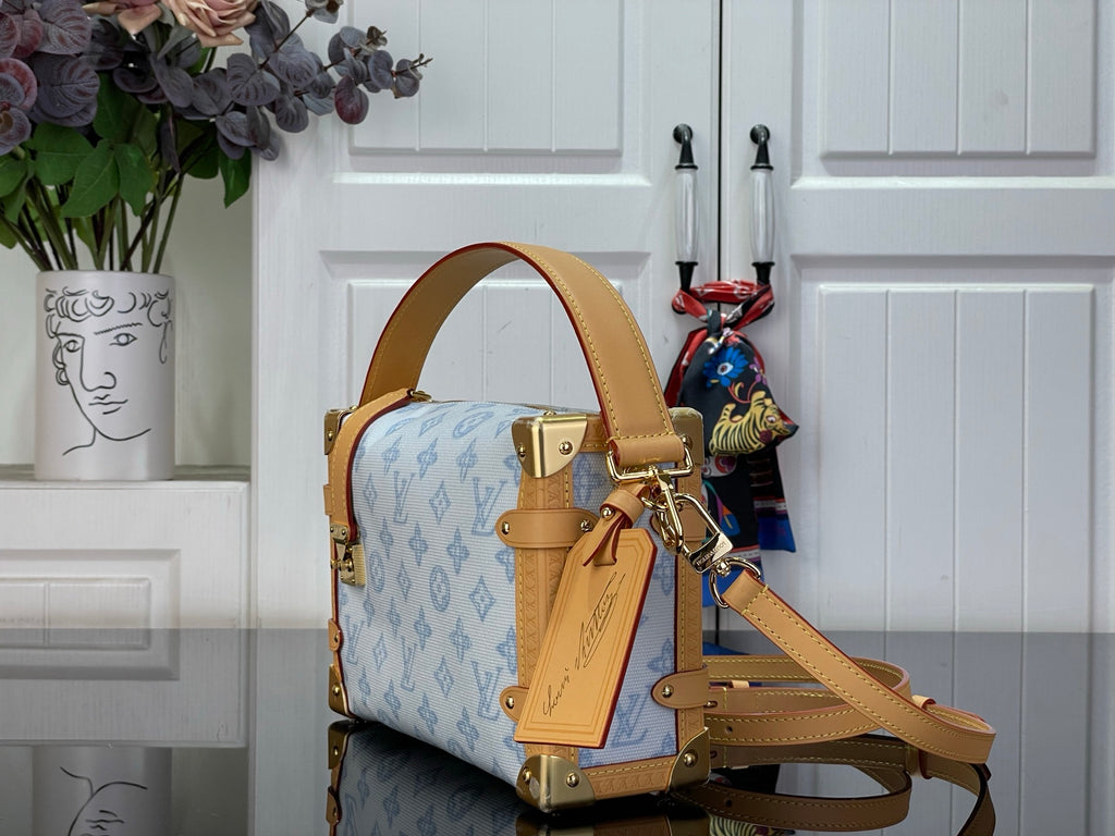 Blue monogram handbag side view with tan leather strap and gold hardware