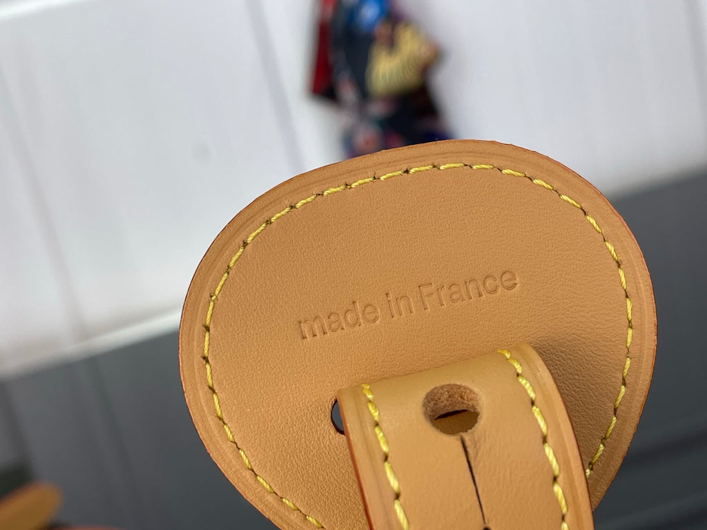 Louis Vuitton leather tag detail reading “made in France” on bag strap